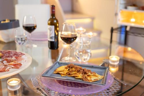 a plate of food on a glass table with wine at Terre Dell'Amore in Grosseto