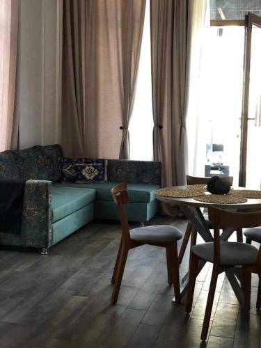 Delmar Residence في باكو: غرفة معيشة مع أريكة وطاولة وكراسي