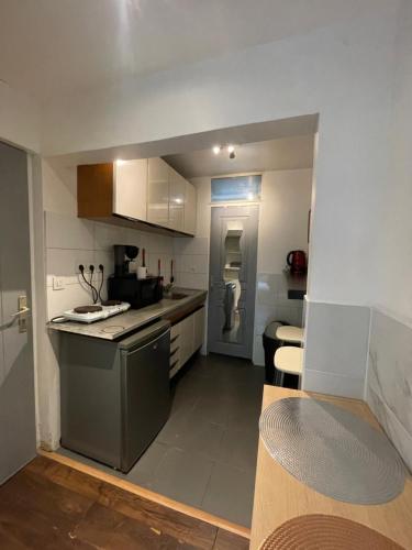 une cuisine avec une cuisinière et un comptoir dans l'établissement Petit appartement idéal pour deux personnes, offrant une belle vue sur jardin, proche des commodités et à moins de 30 minutes de Paris en transport, à Chennevières-sur-Marne