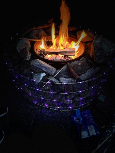 a fire pit with a stick in it with flames at Birch Tree Cottage in Westport