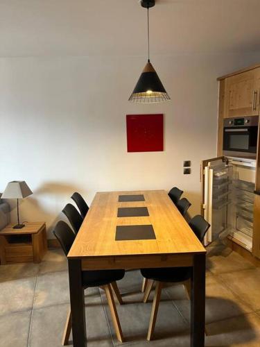 une cuisine avec une table en bois entourée de chaises. dans l'établissement Valmorel Ski au pied avec Parking couvert !, à Valmorel