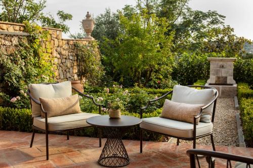 two chairs and a table on a patio at Palazzo Tiglio - A Small Luxury Hotels of the World in San Pancrazio