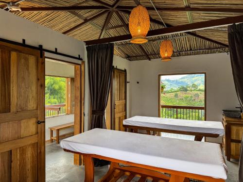 a room with two tables and a window at Finca del Café - Casa Bourbon in Santa Rosa de Cabal
