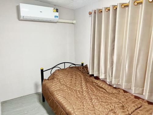 a bed in a room with a window and a heater at บ้านเช่า Wilai Townhome Udon in Udon Thani