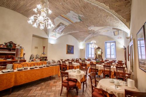 um restaurante com mesas e cadeiras e um lustre em Hotel Fortuna em Perugia