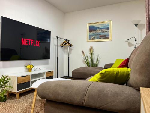 a living room with a couch and a tv at Apartmani Moslavina, free big parking, workspace, crib, satin cotton sheets in Kutina