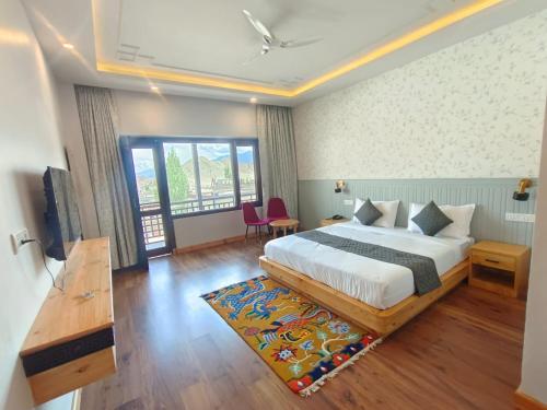 a hotel room with a bed and a table and chairs at The Clove Ladakh in Leh