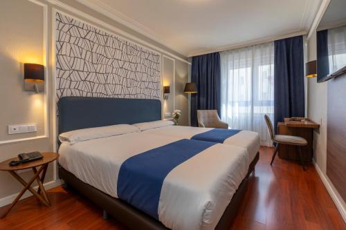 Postel nebo postele na pokoji v ubytování Hotel Corona de Castilla Burgos
