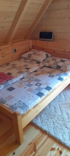 a bed in a cabin with a wooden floor at Komovi-Apartment in Kolašin