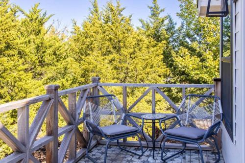 two chairs and a table on a deck with trees at Paradise Tiger Mansion 6BR W Pool, Weddings Events in Waxahachie