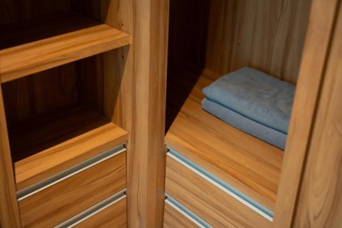 a wooden cabinet with a blue towel in it at Patong Kalim Unparalleled Sea View B&B Resort in Patong Beach