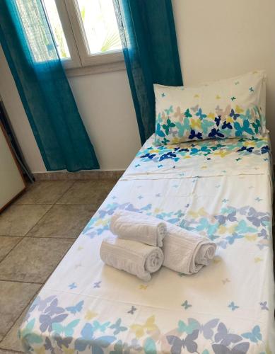 a bedroom with a bed with towels on it at Casa mosaico IUN R9770 in SantʼAntìoco