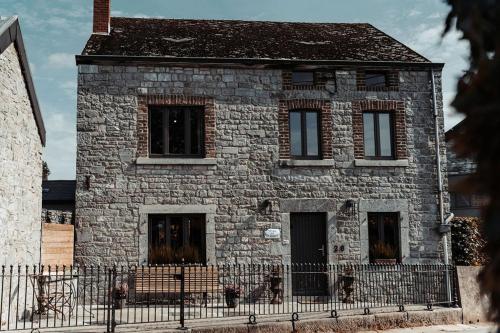 an old stone house with a fence in front of it at Les Soeurettes in Durbuy