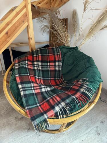 a blanket sitting on top of a wooden chair at KURNIK - Domek pod lasem in Sztabin