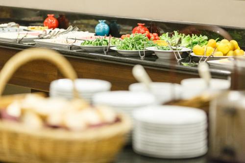 een buffet met borden, fruit en groenten bij Antroyal Hotel in Antalya
