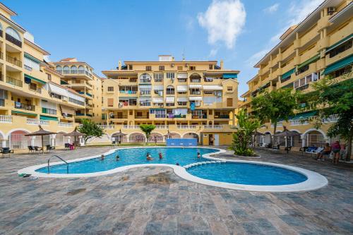 a swimming pool in front of a large building at La Mata Oasis Sunrise in La Mata