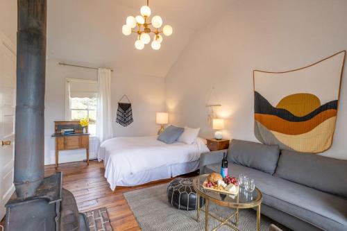a living room with a bed and a couch at Dennen's Victorian Farmhouse in Little River