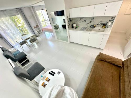 une cuisine avec des armoires blanches et une table et des chaises dans l'établissement Studio Trip In Paris - Gare de l'Est, à Paris