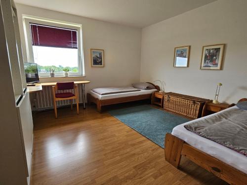a bedroom with a bed and a desk and a window at Panoramablick - günstig übernachten im Ruhrgebiet in Gladbeck