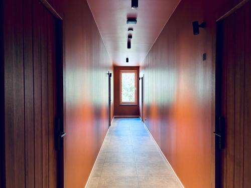 a hallway with wooden walls and a long hallway with a window at Platforma2b in Šiauliai