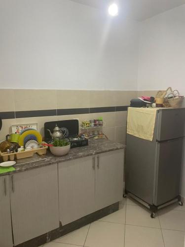 a kitchen with a counter top with alot of clutter at Appartement Familial à Martil in Martil