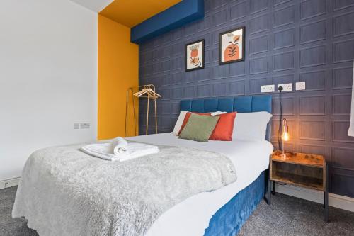 a bedroom with a large bed and a blue wall at 4 Beds 3 Bath (2-ensuites) Free Parking 75Mbps in Stoke on Trent