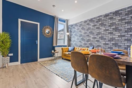 a dining room with blue walls and a table and chairs at 4 Beds 3 Bath (2-ensuites) Free Parking 75Mbps in Stoke on Trent