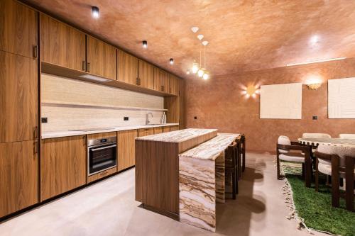 une cuisine avec des armoires en bois et une table avec des chaises dans l'établissement Exceptional Duplex - 6BR-12P - Montorgueil, à Paris