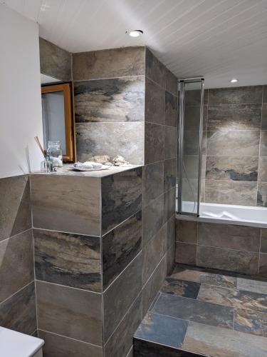 La salle de bains est pourvue d'une douche à l'italienne et d'une baignoire. dans l'établissement chambre d'hôte La Fontaine, à Saint-Michel-Lapujade