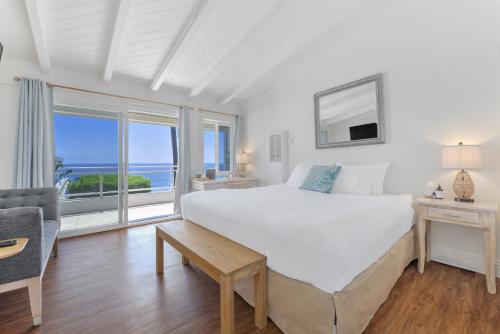 a bedroom with a large bed with a view of the ocean at Laguna Surf Lodge by SCP Hotels in Laguna Beach