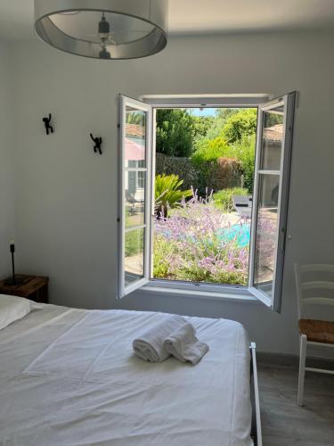 a white bedroom with a bed and a window at Très belle villa, 4 chambres, piscine et jacuzzi in Rivedoux-Plage