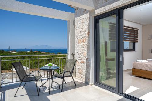 a room with a balcony with a table and chairs at Edward Stone Villa in Tragaki