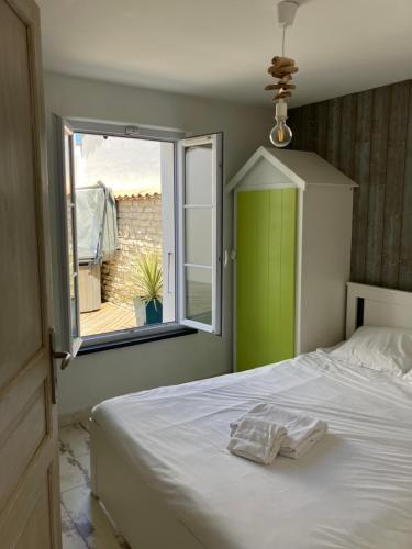 a bedroom with a bed with a green door and a window at Très belle villa, 4 chambres, piscine et jacuzzi in Rivedoux-Plage