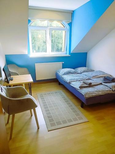 a bedroom with a bed and a desk and a window at Zajazd u Hermanów in Olsztyn