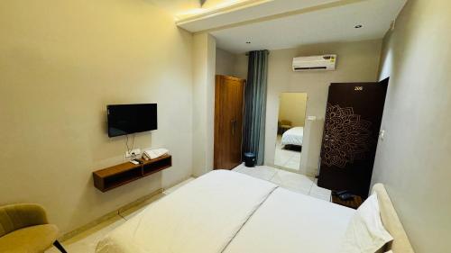 a hotel room with a bed and a television at Hari Leela fort view palace in Chittaurgarh