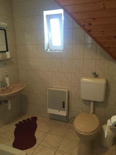a bathroom with a toilet and a sink and a window at Holiday home in Gyenesdias - Balaton 18816 in Gyenesdiás