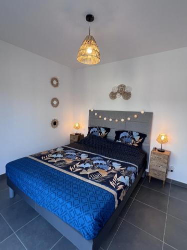une chambre avec un lit avec une couette bleue dans l'établissement mini villa duplex Bonifacio 70m2, à Bonifacio