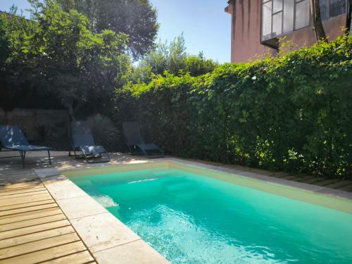 - une piscine dans une cour à côté d'un bâtiment dans l'établissement Maison, piscine, climatisation parking, 10min à pied du centre, à Avignon