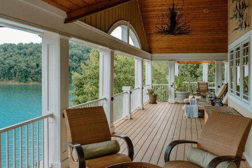 a screened porch with chairs and a view of the water at Waterfront Home on Norris Lake with Boat Slip! in La Follette