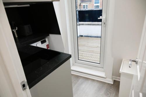 a bathroom with a door open to a balcony at New Luxury Apartments in Central London Next to Shops, Cafes, Bars & Metro in London