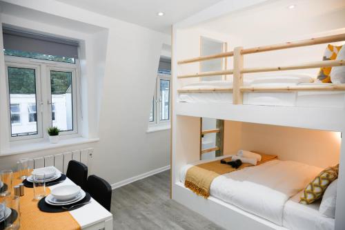 a bedroom with a bunk bed and a dining room at New Luxury Apartments in Central London Next to Shops, Cafes, Bars & Metro in London