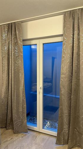 a room with a sliding glass door with a window at Quiet 1-Bedroom Apartment - Ideal for small Familiy & Work Stays in Munich