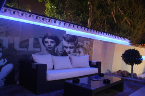 a couch with pillows in front of a wall at Hotel Años 50 in Torremolinos