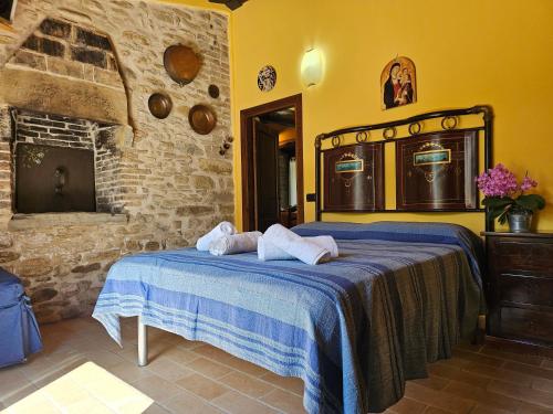 a bedroom with a bed and a stone wall at Agriturismo Ca Serrantonio - Ferri Appartamento Puccini in Urbania