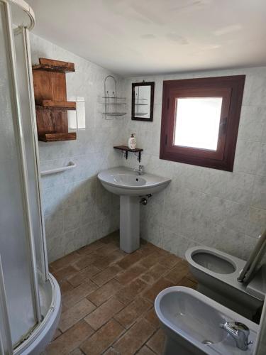 a bathroom with a sink and a toilet at Agriturismo Ca Serrantonio - Ferri Appartamento Puccini in Urbania