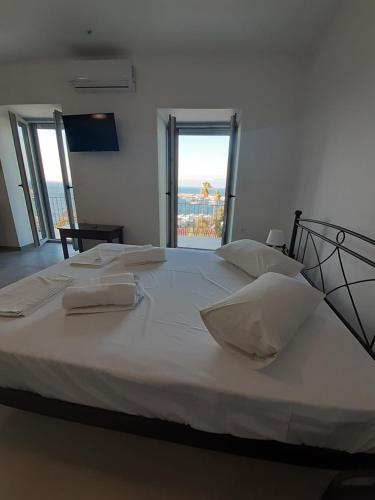 a large white bed with two white pillows on it at ANGIRA - Koroni Apartments in Koroni