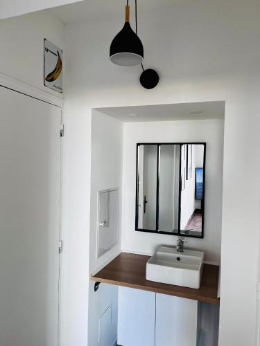 une salle de bain avec un lavabo et un miroir dans l'établissement Charmant appartement climatisée près de la mer, à Perpignan