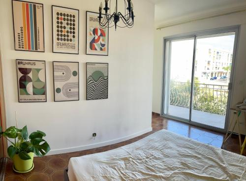 - une chambre avec un lit et des photos sur le mur dans l'établissement Charmant appartement climatisée près de la mer, à Perpignan
