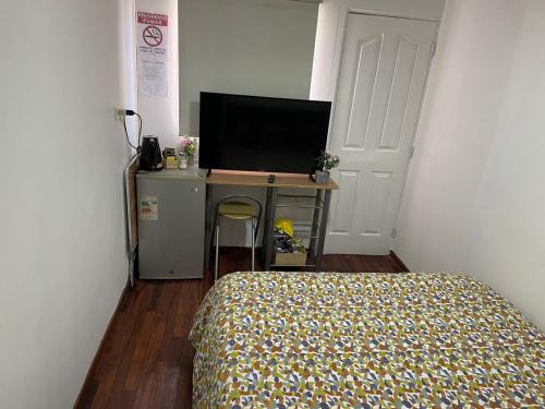 a bedroom with a bed and a television on a desk at Alojamiento Puente Alto in Santiago