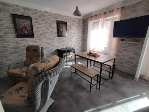 a living room with a couch and a table at Jolie maison de bourg tout équipée 10km d'Ambert in Saint-Amant-Roche-Savine